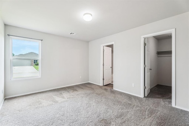 1016 N Deer Court Way, Mustang, OK 73064 - unfurnished bedroom featuring carpet, a walk in closet, and a closet