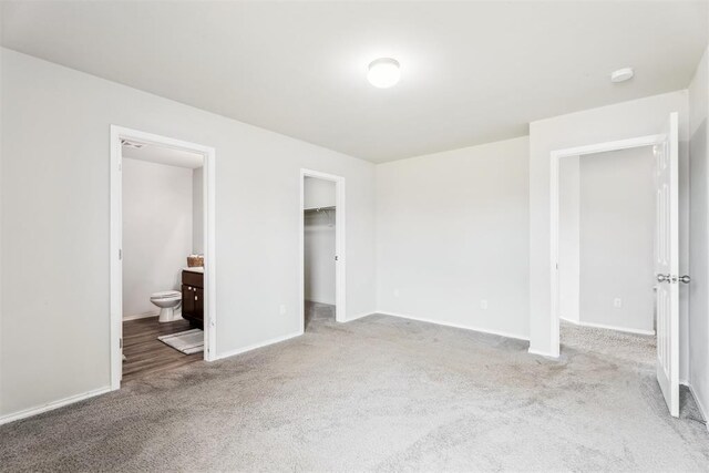 1016 N Deer Court Way, Mustang, OK 73064 - unfurnished bedroom featuring carpet flooring, a walk in closet, connected bathroom, and a closet