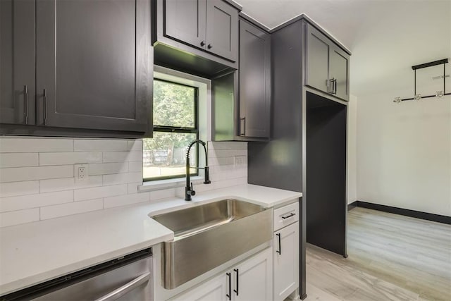 2325 SW Binkley St, Oklahoma City, OK 73119 - kitchen with stainless steel dishwasher, backsplash, light countertops, and light wood-style floors
