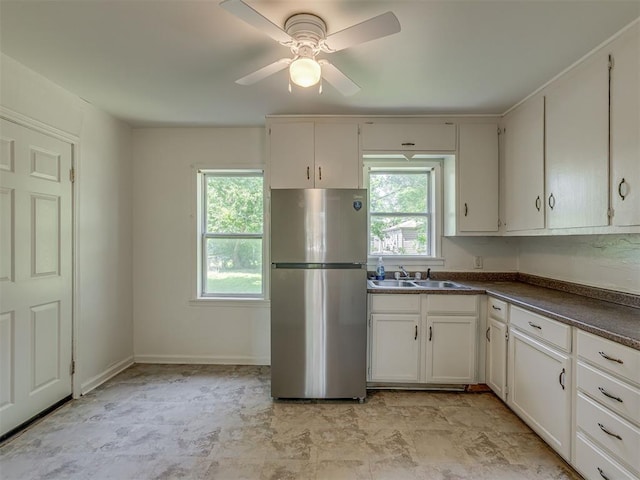 7235 SE 15th St, Midwest City, OK 73110 - kitchen featuring freestanding refrigerator, dark countertops, a ceiling fan, and white cabinets