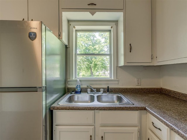 7235 SE 15th St, Midwest City, OK 73110 - kitchen featuring freestanding refrigerator, plenty of natural light, and white cabinetry