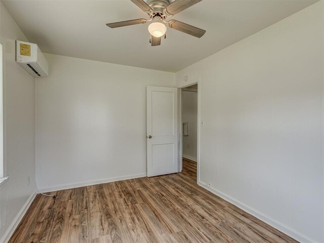 7235 SE 15th St, Midwest City, OK 73110 - unfurnished room featuring a wall mounted air conditioner, wood finished floors, and ceiling fan
