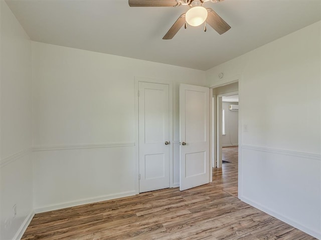 7235 SE 15th St, Midwest City, OK 73110 - empty room featuring wood finished floors, a ceiling fan, and an AC wall unit