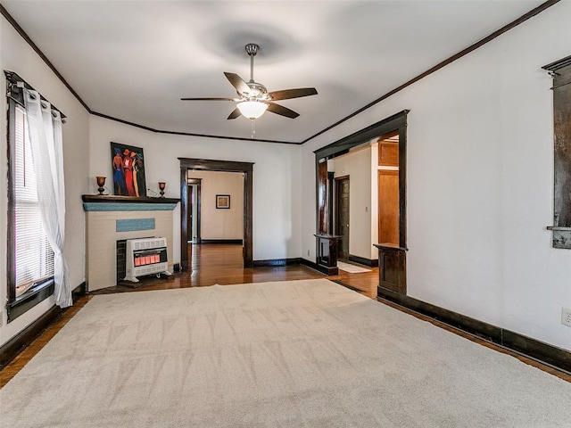 312 NW 24th St, Oklahoma City, OK 73103 - unfurnished living room featuring heating unit, crown molding, a ceiling fan, a fireplace, and wood finished floors