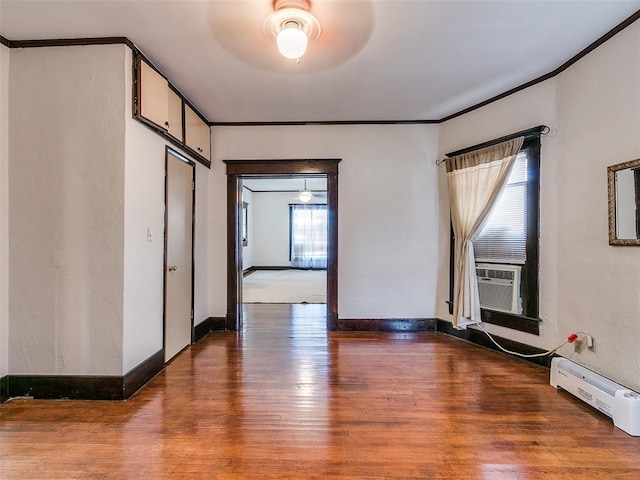 312 NW 24th St, Oklahoma City, OK 73103 - empty room featuring wood finished floors, baseboard heating, crown molding, ceiling fan, and cooling unit