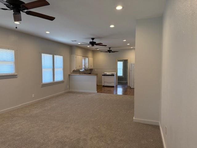 unfurnished living room featuring a ceiling fan, recessed lighting, and carpet