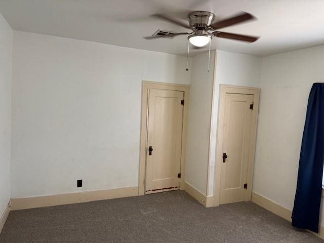 carpeted spare room featuring a ceiling fan and baseboards