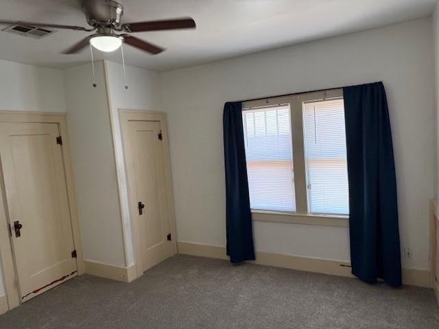 unfurnished bedroom featuring light colored carpet, multiple windows, and a ceiling fan
