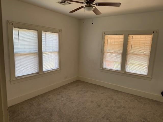 spare room with light colored carpet and a ceiling fan