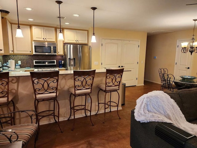 3908 Southwestern Ave, Edmond, OK 73034 - kitchen featuring stainless steel appliances, backsplash, a kitchen breakfast bar, recessed lighting, and light countertops