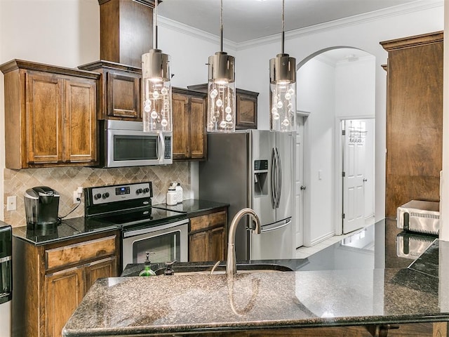 19940 Vivace Ct, Edmond, OK 73013 - kitchen with appliances with stainless steel finishes, ornamental molding, arched walkways, decorative backsplash, and dark stone countertops
