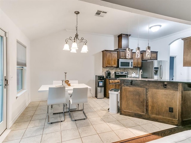 19940 Vivace Ct, Edmond, OK 73013 - kitchen featuring stainless steel appliances, arched walkways, decorative backsplash, light tile patterned floors, and a chandelier