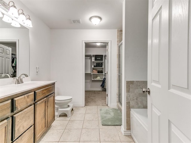 19940 Vivace Ct, Edmond, OK 73013 - full bath featuring a spacious closet, vanity, a shower stall, a garden tub, and tile patterned floors
