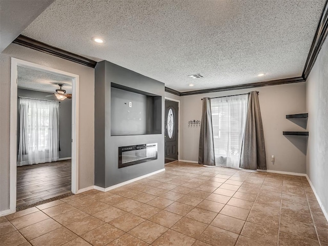 503 W Owens St, El Reno, OK 73036 - unfurnished living room with crown molding, a textured ceiling, a glass covered fireplace, light tile patterned floors, and recessed lighting