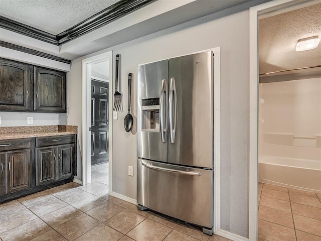 503 W Owens St, El Reno, OK 73036 - kitchen featuring stainless steel refrigerator with ice dispenser, a textured ceiling, light tile patterned flooring, and crown molding