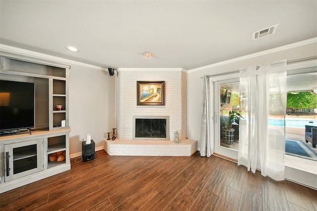 7617 N Ann Arbor Ave, Oklahoma City, OK 73132 - living room with a brick fireplace, crown molding, wood finished floors, and recessed lighting