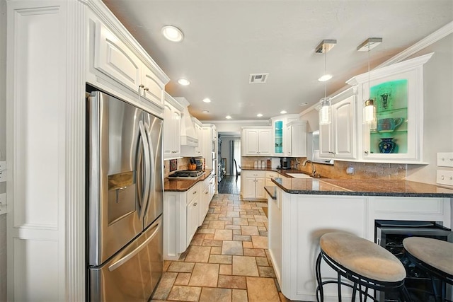 7617 N Ann Arbor Ave, Oklahoma City, OK 73132 - kitchen with stainless steel appliances, stone tile floors, a peninsula, glass insert cabinets, and backsplash
