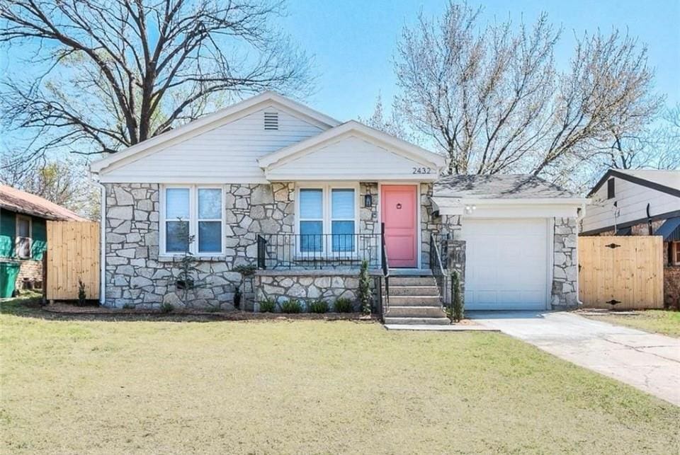 2432 NW 36th St, Oklahoma City, OK 73112 - view of front of home with stone siding, a garage, covered porch, and driveway