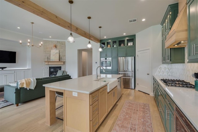 3824 Library Ln, Edmond, OK 73034 - kitchen featuring stainless steel appliances, green cabinetry, open floor plan, custom exhaust hood, and decorative backsplash