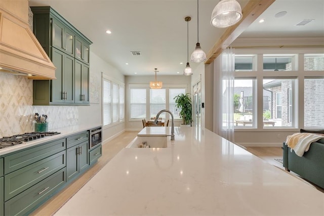 3824 Library Ln, Edmond, OK 73034 - kitchen featuring green cabinets, premium range hood, stainless steel gas stovetop, tasteful backsplash, and pendant lighting