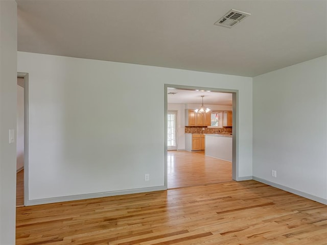 2822 N Market Ave, Shawnee, OK 74804 - spare room with light wood-style floors and a chandelier
