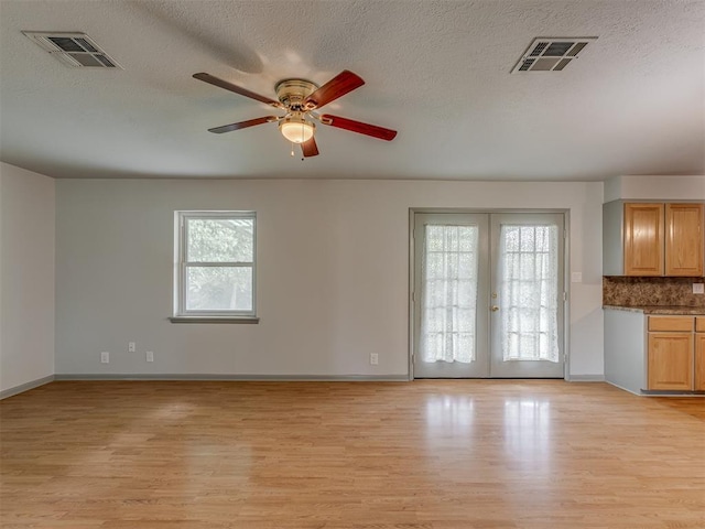 2822 N Market Ave, Shawnee, OK 74804 - spare room with light wood finished floors, a ceiling fan, french doors, and a textured ceiling