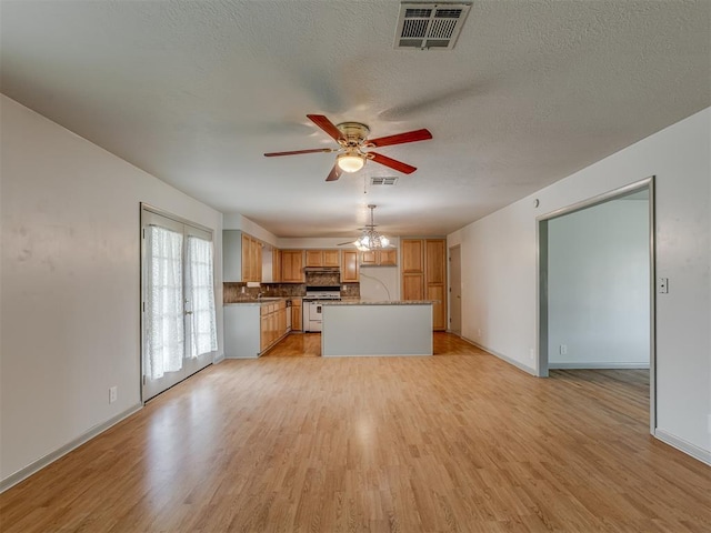 2822 N Market Ave, Shawnee, OK 74804 - unfurnished living room featuring a ceiling fan, light wood-style flooring, and a textured ceiling