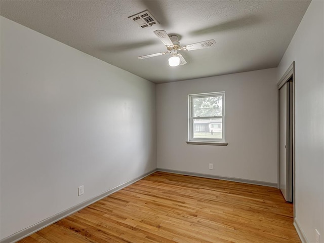2822 N Market Ave, Shawnee, OK 74804 - unfurnished bedroom with light wood finished floors, a textured ceiling, and ceiling fan