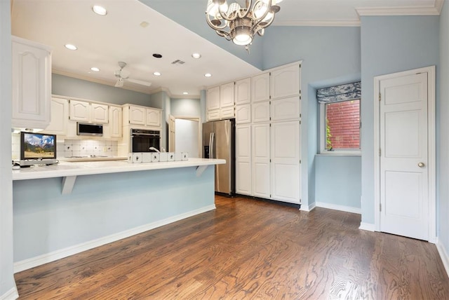 2825 NW Grand Blvd Unit 3, Oklahoma City, OK 73116 - kitchen with stainless steel appliances, a peninsula, white cabinets, ornamental molding, and a breakfast bar area