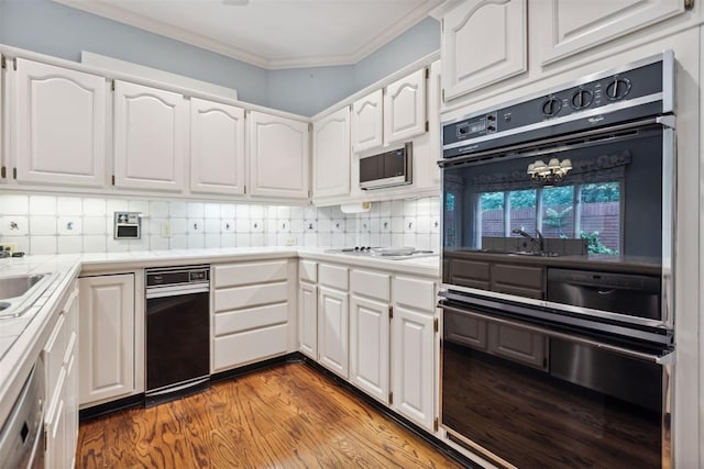 2825 NW Grand Blvd Unit 3, Oklahoma City, OK 73116 - kitchen featuring black oven, tile counters, wood finished floors, crown molding, and white cabinetry