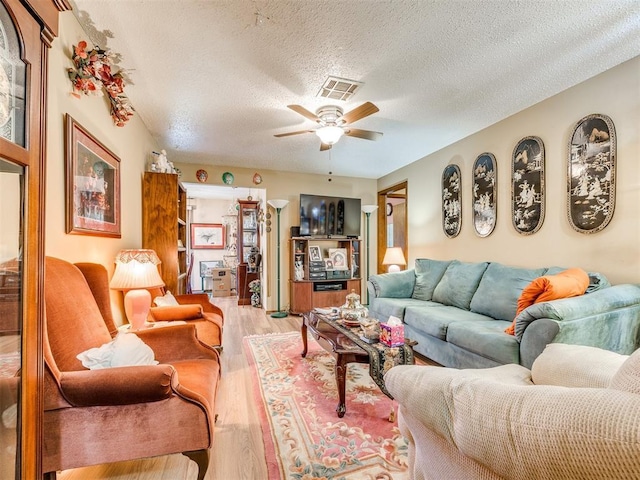 4021 E Larkwood Dr, Del City, OK 73115 - living room with wood finished floors, a textured ceiling, and a ceiling fan