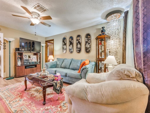 4021 E Larkwood Dr, Del City, OK 73115 - living area with light wood finished floors, a ceiling fan, and a textured ceiling