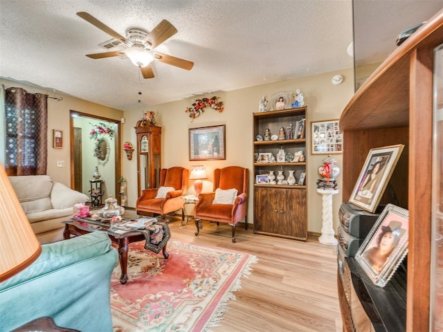 4021 E Larkwood Dr, Del City, OK 73115 - living area featuring light wood-type flooring, a ceiling fan, and a textured ceiling