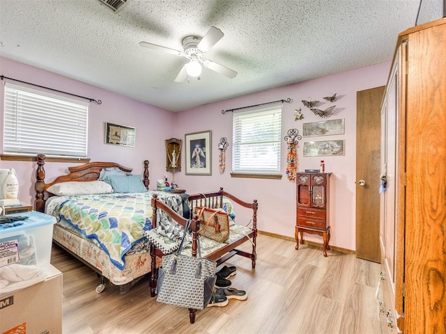 4021 E Larkwood Dr, Del City, OK 73115 - bedroom featuring light wood-type flooring, a textured ceiling, and a ceiling fan