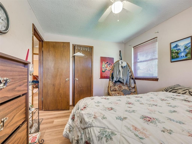 4021 E Larkwood Dr, Del City, OK 73115 - bedroom with light wood-type flooring, a textured ceiling, multiple closets, and a ceiling fan