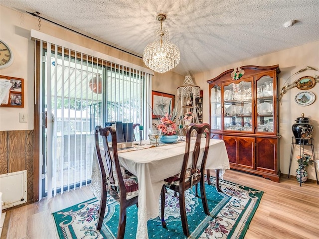 4021 E Larkwood Dr, Del City, OK 73115 - dining room featuring a chandelier, light wood-style flooring, and a textured ceiling