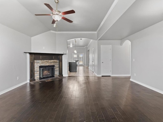 3325 NW 161st St, Edmond, OK 73013 - unfurnished living room with a ceiling fan, arched walkways, a stone fireplace, hardwood / wood-style flooring, and ornamental molding