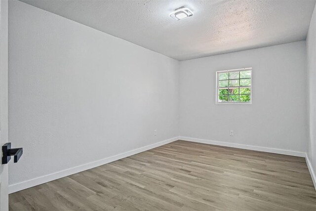 813 SW 56th St, Oklahoma City, OK 73109 - unfurnished room featuring wood finished floors and a textured ceiling