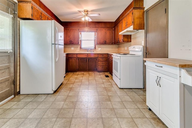 1817 W Harrison Ave, Guthrie, OK 73044 - kitchen featuring white appliances, under cabinet range hood, light countertops, ceiling fan, and brown cabinetry