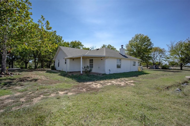 45350 Bob Crouch Rd, Tecumseh, OK 74873 - view of home's exterior with a chimney, a yard, and a patio area