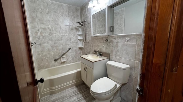 425 Mohawk Dr, Pauls Valley, OK 73075 - bathroom with tile walls, vanity, shower / bath combination, wood finished floors, and ornamental molding
