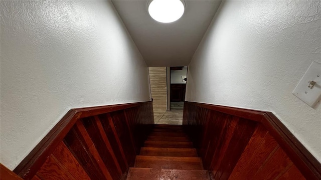425 Mohawk Dr, Pauls Valley, OK 73075 - staircase featuring wainscoting, wooden walls, and a textured wall