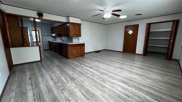 425 Mohawk Dr, Pauls Valley, OK 73075 - kitchen featuring a textured ceiling, a ceiling fan, light wood-style floors, light countertops, and brown cabinets