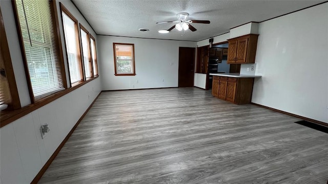 425 Mohawk Dr, Pauls Valley, OK 73075 - unfurnished living room featuring ceiling fan, wood finished floors, and a textured ceiling