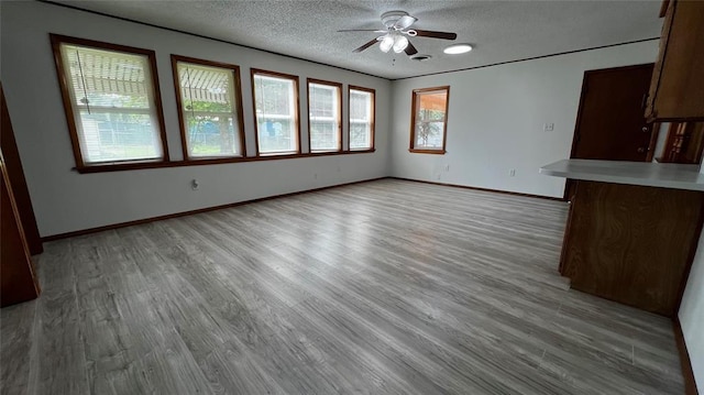 425 Mohawk Dr, Pauls Valley, OK 73075 - unfurnished living room with ceiling fan, wood finished floors, and a textured ceiling