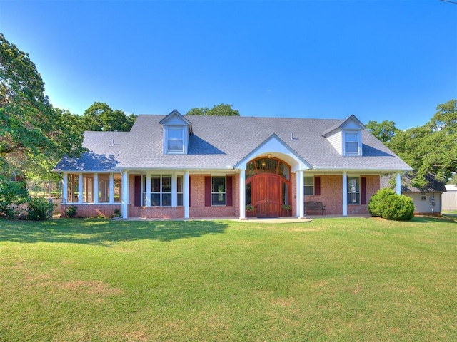 1124 Hill View Dr, Guthrie, OK 73044 - new england style home featuring a porch, brick siding, a front lawn, and roof with shingles