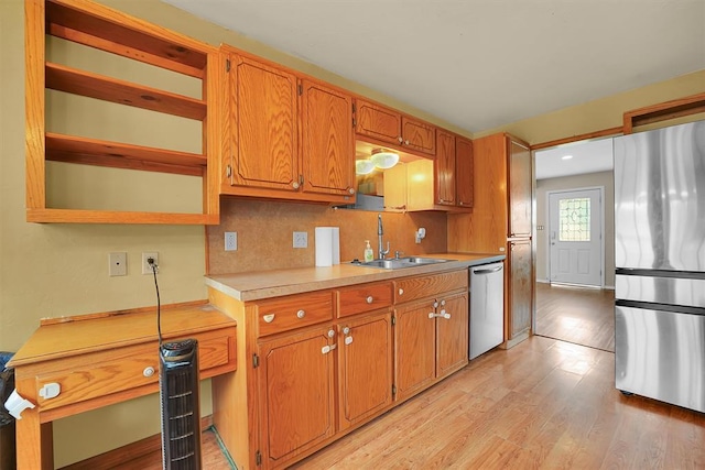 231 W Polk St, Mangum, OK 73554 - kitchen featuring stainless steel appliances, light countertops, light wood-style flooring, brown cabinets, and backsplash