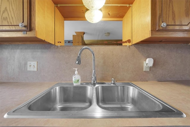 231 W Polk St, Mangum, OK 73554 - kitchen view of light countertops, decorative backsplash, and brown cabinetry