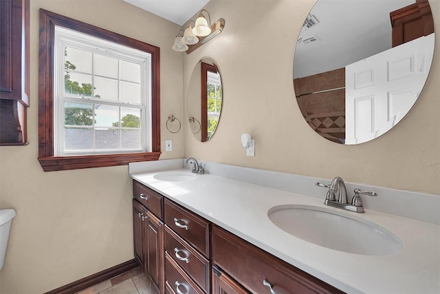 231 W Polk St, Mangum, OK 73554 - full bath with healthy amount of natural light, double vanity, and tile patterned flooring