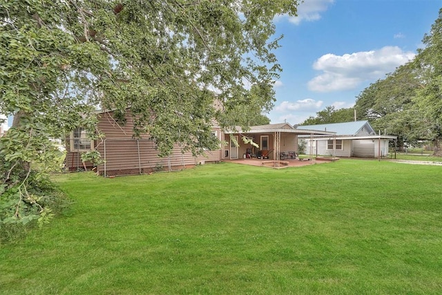 231 W Polk St, Mangum, OK 73554 - view of grassy yard featuring a patio area and a carport